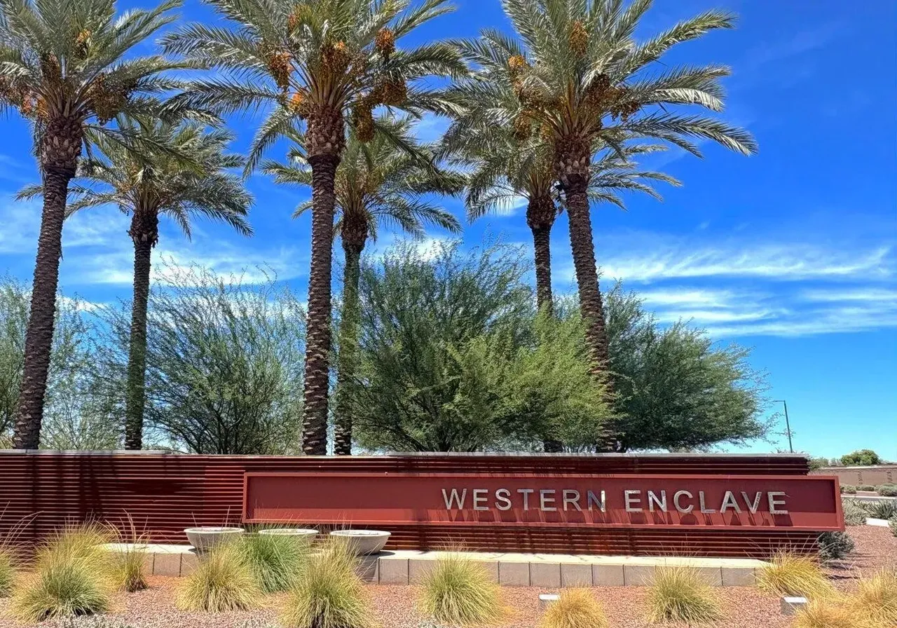 Western Enclave entry monument framed by palms
